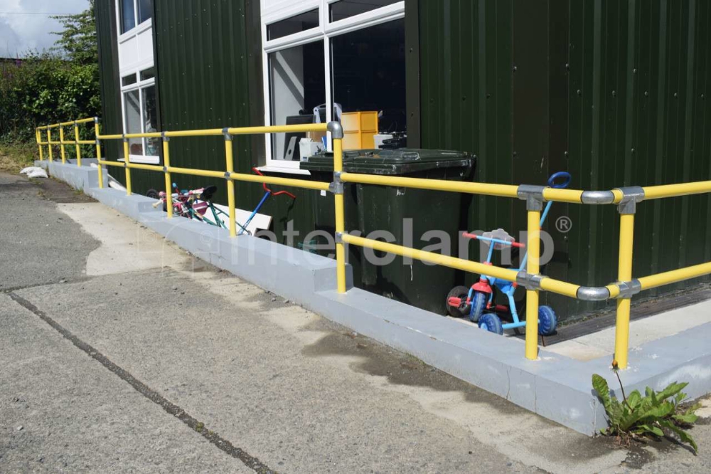 Interclamp safety balustrade in retail carpark, powdercoated in safety yellow.